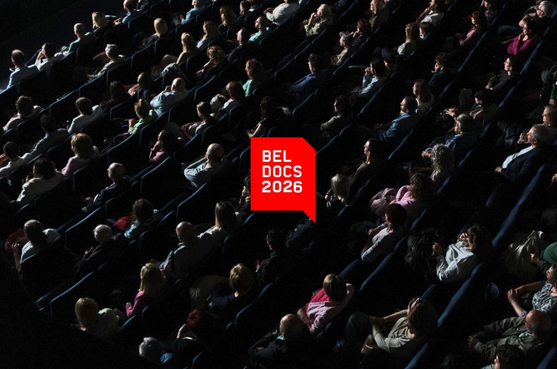 Publika u bioskopskoj sali tokom projekcije na Beldocs festivalu 2026 u Beogradu, sa istaknutim crvenim Beldocs logotipom u centru slike.
