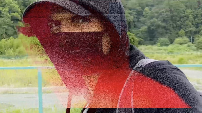 Apstraktni vizuelni prikaz osobe sa kapuljačom i digitalnim efektom distorzije u prirodnom okruženju, inspirisan temom zvuka i percepcije.. izložba Less Soundless