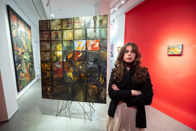 Nikolina Nikolić stoji pored slike iz ciklusa „Zapisi 72“ u Aleksić galeriji savremene umetnosti u Kragujevcu