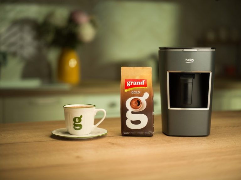 Beko aparat za pripremu domaće kafe pored pakovanja Grand kafe i šoljice na kuhinjskom pultu