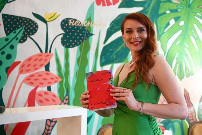 Miljana Marić predstavlja roman Delovi slagalice na promociji u Beogradu, držeći knjigu u rukama